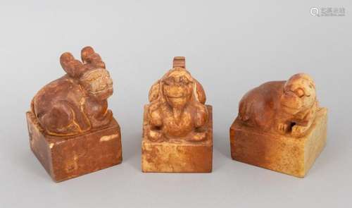 Three Chinese russet jadeite seals in the form of seated myt...