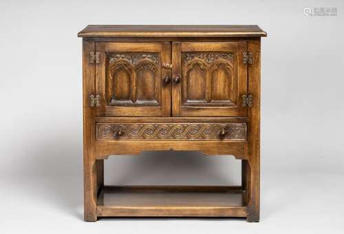 An oak chest fitted with a pair of panel doors above a drawe...