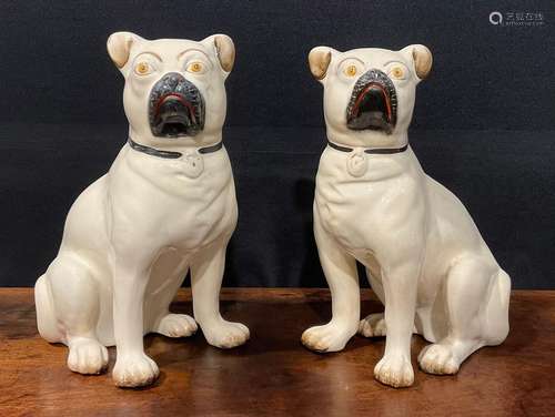 A pair of 19th century Staffordshire models of pugs, seated ...