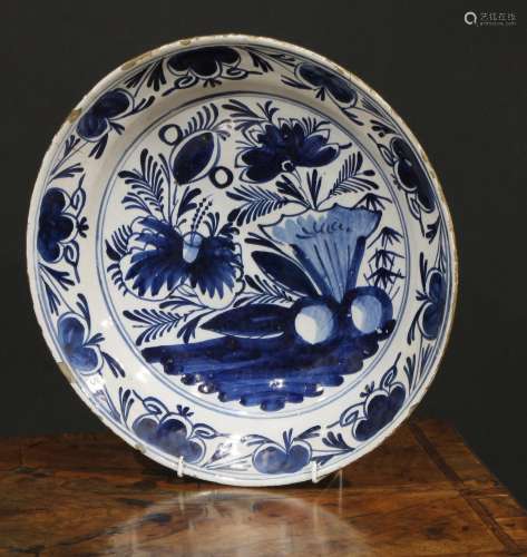 An 18th century Delft circular charger, painted in tones of ...