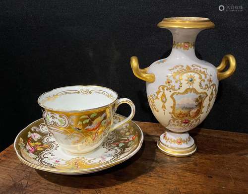 A Coalport cup and saucer, painted with flowers and birds on...