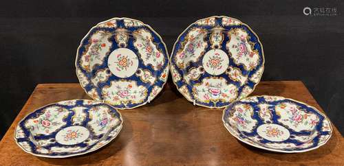 A set of four Worcester shaped circular plates, painted with...