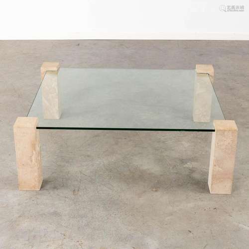 A coffee table with travertine legs, glass top. Circa 1980. ...