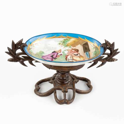 A porlceian bowl with hand-painted decor mounted in a wood f...