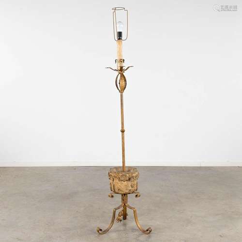 A wrought iron standing lamp with an antique stone mortar. (...