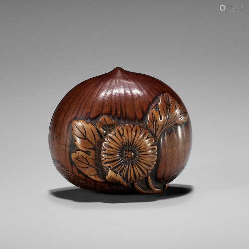 AN EARLY AUTUMNAL WOOD NETSUKE OF A CHESTNUT WITH CHRYSANTHE...
