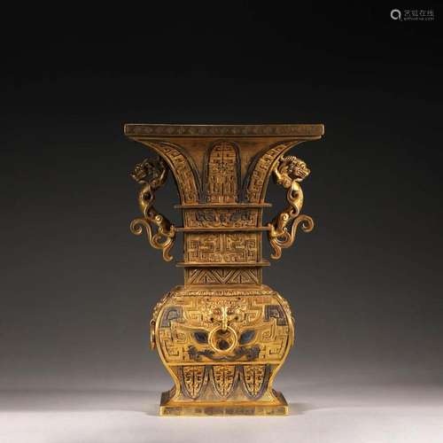 A TAOTIE PATTERNED GILDING COPPER ZUN WITH DRAGON SHAPED EAR...