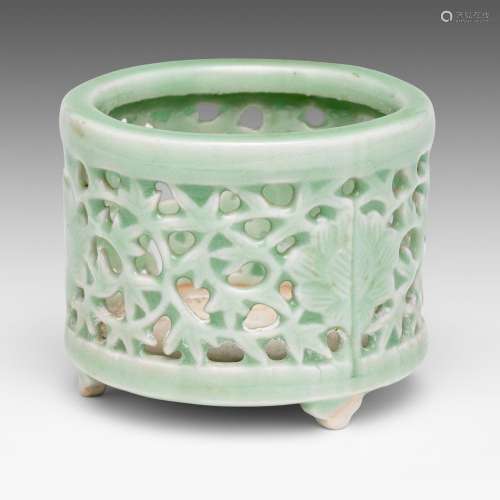A Chinese celadon glazed reticulated 'Flower' tripod censer,...