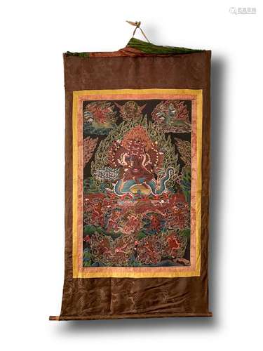 A 19th/20th century thangka with a central wrathful deity on...