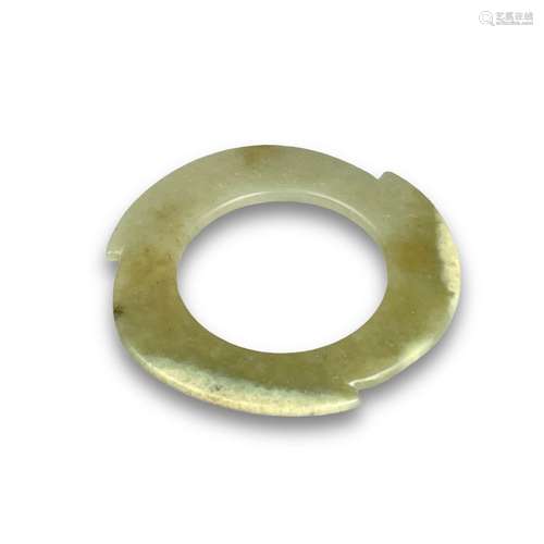 A pale celadon jade notched disc, xuanji, late Neolithic per...