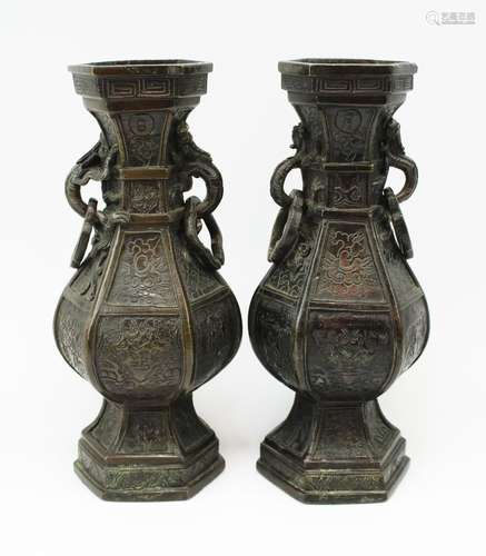 A pair of hexagonal bronze vases with rings suspended from c...