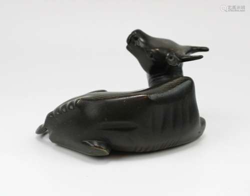 A bronze paperweight in the form of a reclining buffalo