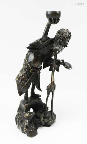 A bronze incense stick holder in the form of an Immortal