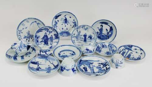 A group of unrelated blue and white cups and saucers