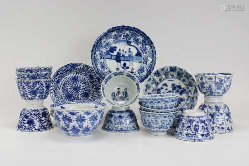A group of various blue and white cups and saucers
