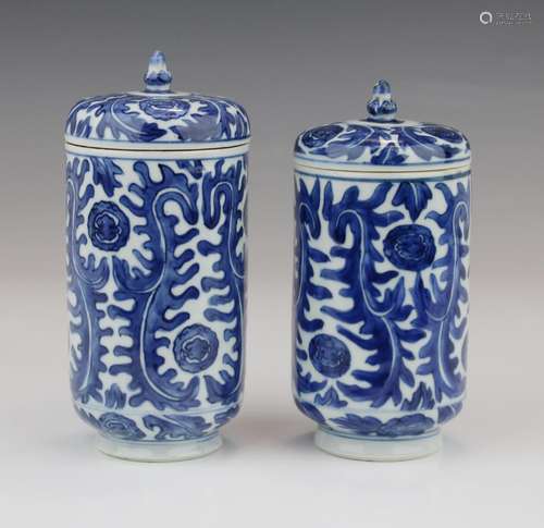 Two tall cilindrical blue and white jars and covers