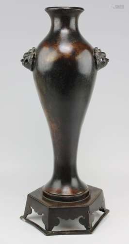 A Ming bronze vase on raised foot with foo-dog handles