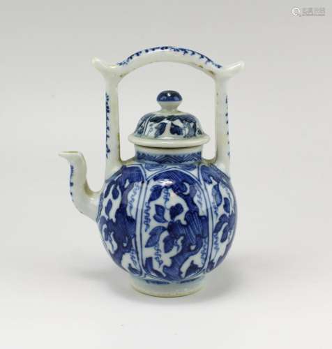 A blue and white teapot with arch-handle