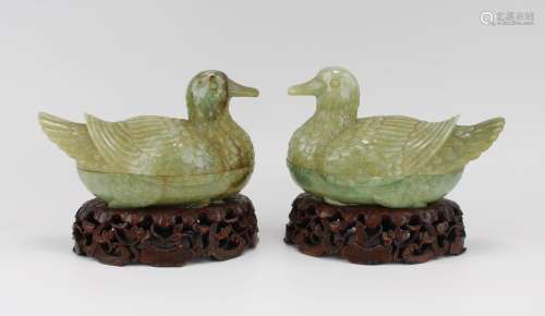 A pair of jadeite carved boxes in the shape of ducks on wood...