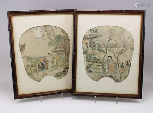 A pair of framed paper fans with figures