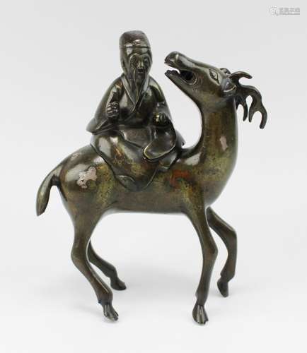 A bronze censer of Shou Lao on a deer, inlaid with silver an...