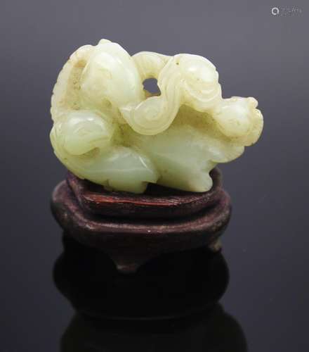 A pale celadon jade 'san yang kai tai' carving on a wooden b...