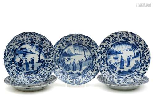 A set of five large blue and white plates with figures