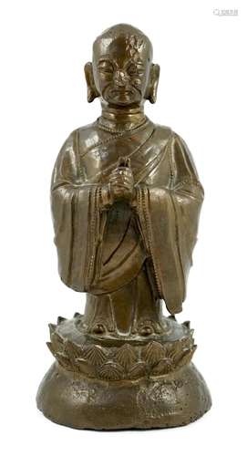 A Chinese bronze figure of a standing luohan, late Ming dyna...