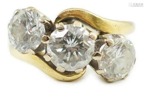 A modern 18ct gold and three stone diamond set crossover rin...