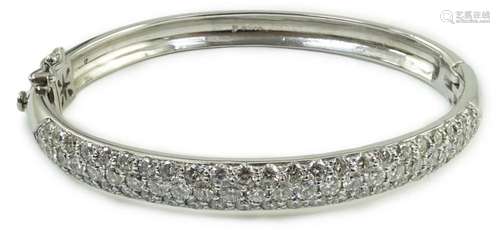 A modern 18ct white gold and pave set diamond hinged bangle