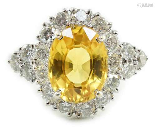 A modern 18ct white gold and single oval cut yellow sapphire...