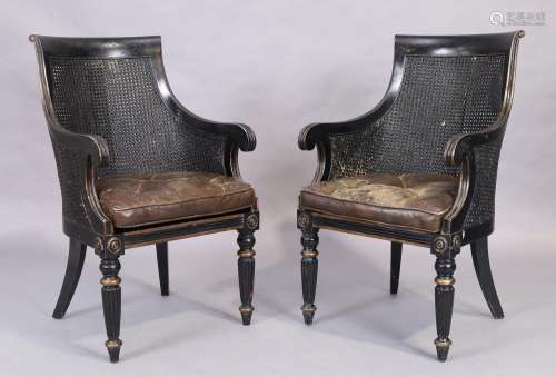 A pair of ebonised caned armchairs, in the Regency style, 20...