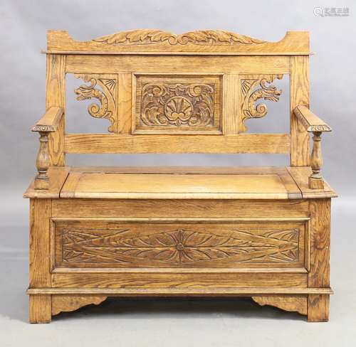 A carved oak box seat settle, second quarter 20th century, 9...