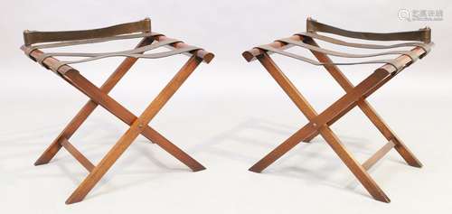 A pair of mahogany folding luggage racks with leather straps...