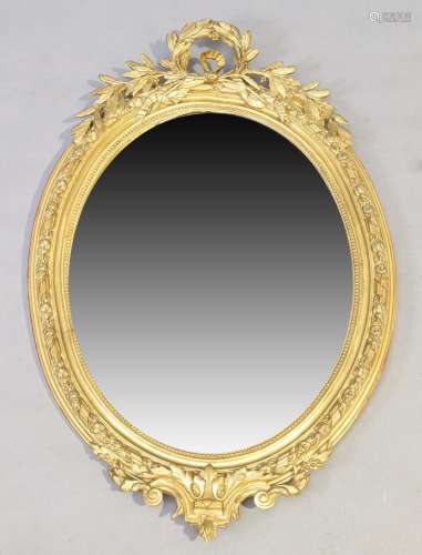 A French oval giltwood and gesso mirror, 19th century, carve...