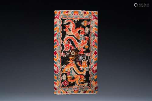 A Tibetan rug with two dragons chasing the pearl of wisdom, ...