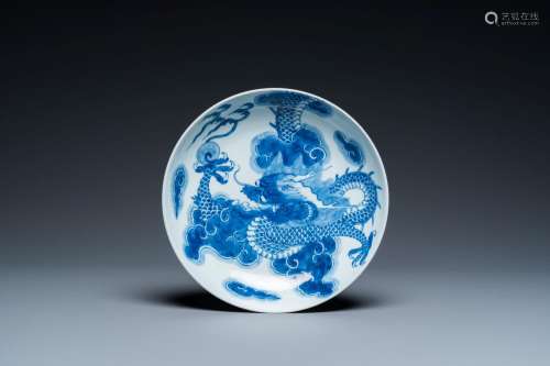 A Chinese blue and white plate with a dragon chasing the fla...