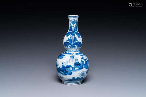 A Chinese blue and white double gourd vase with a scholar an...