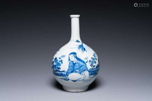 A Japanese blue and white bottle vase with a lady in a lands...