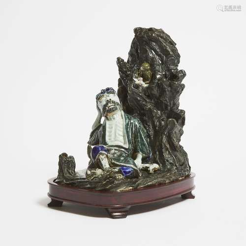 A Glazed Porcelain Group Depicting Li Tieguai Resting Agains...