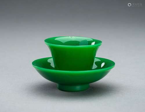 AN APPLE GREEN GLASS CUP AND SAUCER