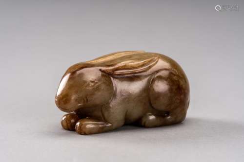 A CELADON AND RUSSET JADE FIGURE OF A RABBIT, QING