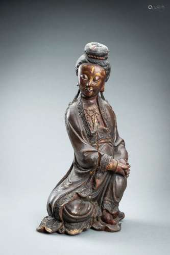 A RED AND GILT-LACQUERED WOOD FIGURE OF GUANYIN, QING DYNAST...
