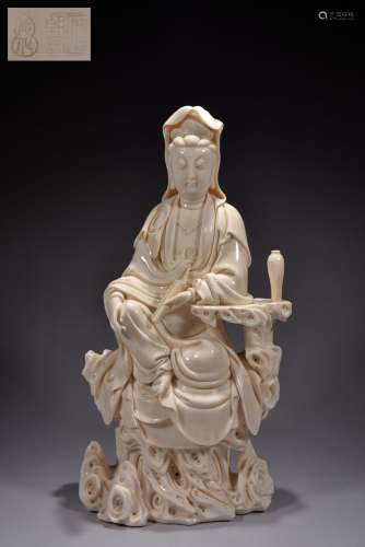Avalokitesvara sits on a rock ornament with lard white scrip...