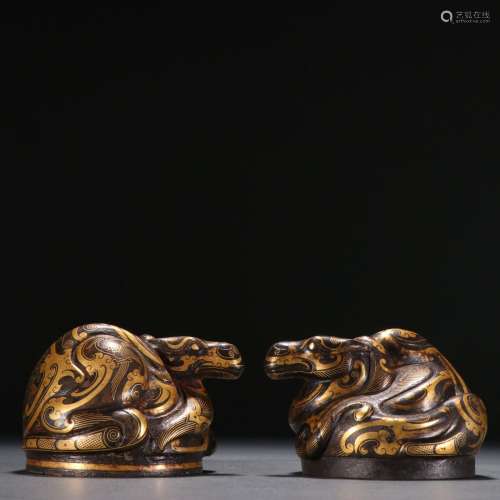 A pair of gold auspicious animal decorations with copper inl...