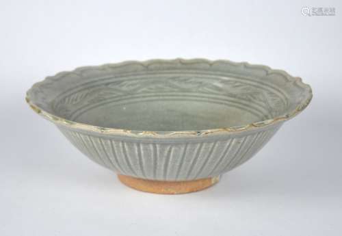 A Chinese large celadon plate with barbed rim & carved patte...
