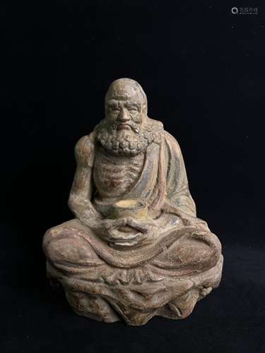 A sitting statue of an arhat carved in Ming wood