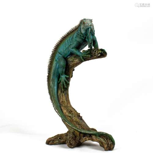 A taxidermic specimen of Iguana perched on a branch, color e...