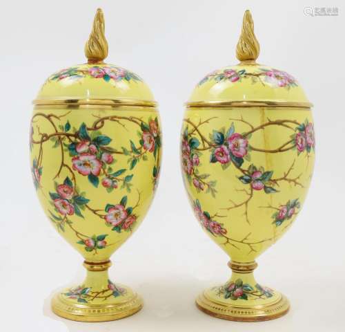 A pair of yellow ground decorative urns and covers, 19th cen...