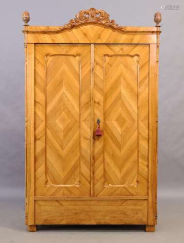 A Biedermeier walnut armoire, 19th century, with carved cres...